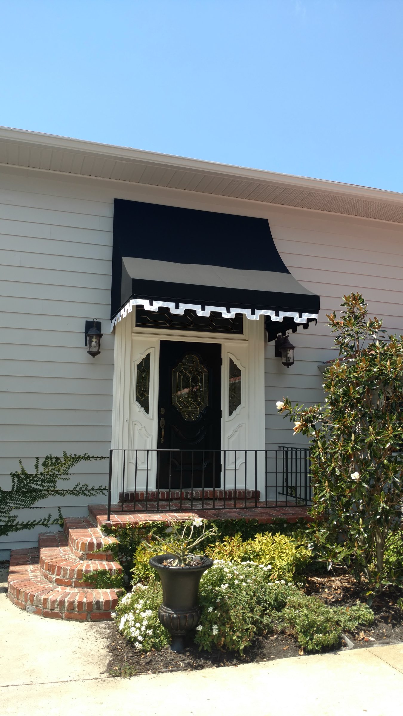 Black fabric canopy with white trim above a front door