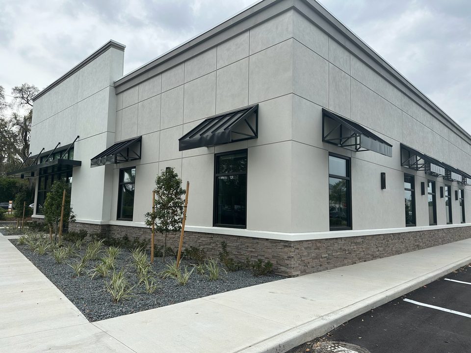 Black awnings around a modern commercial building