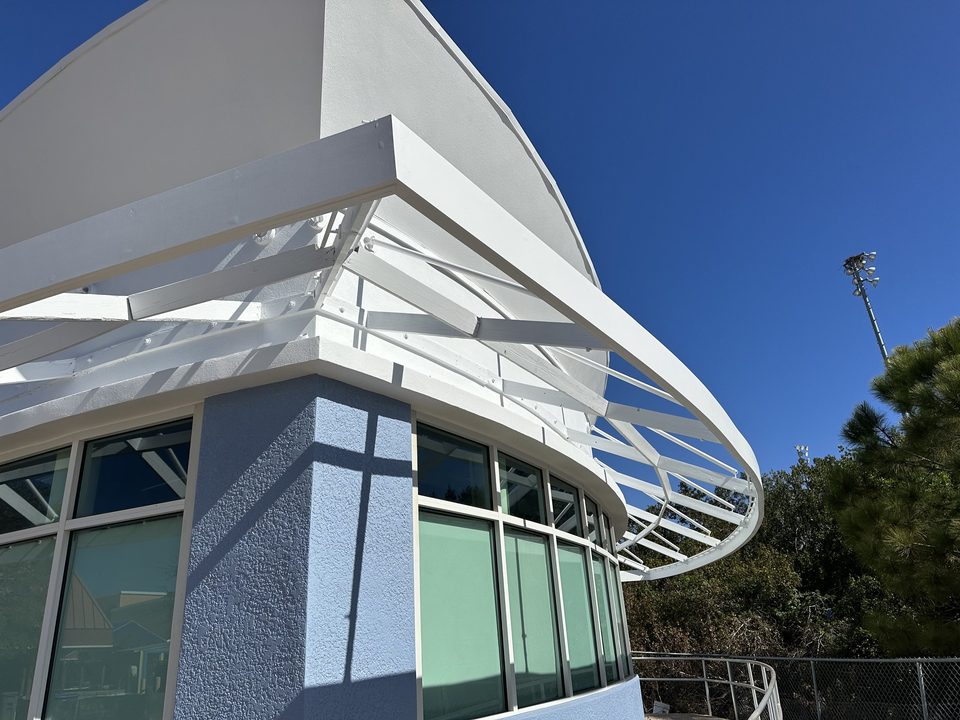 Curved metal canopy frame wrapping a commercial building