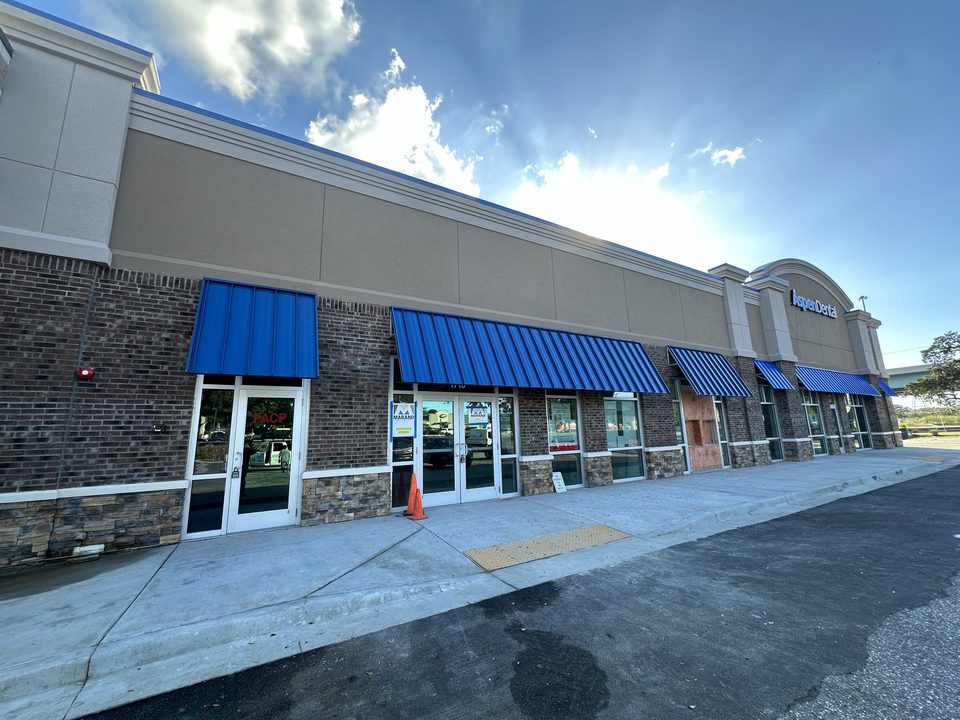 Blue metal awnings above commercial storefront windows