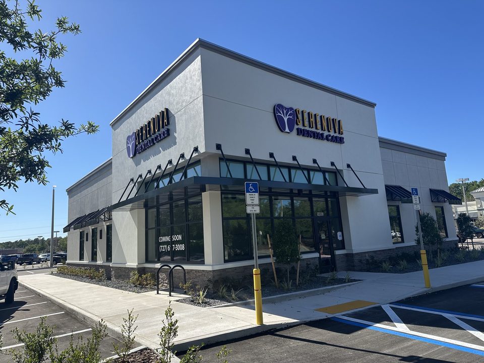 Black entrance and window awnings on a commercial building