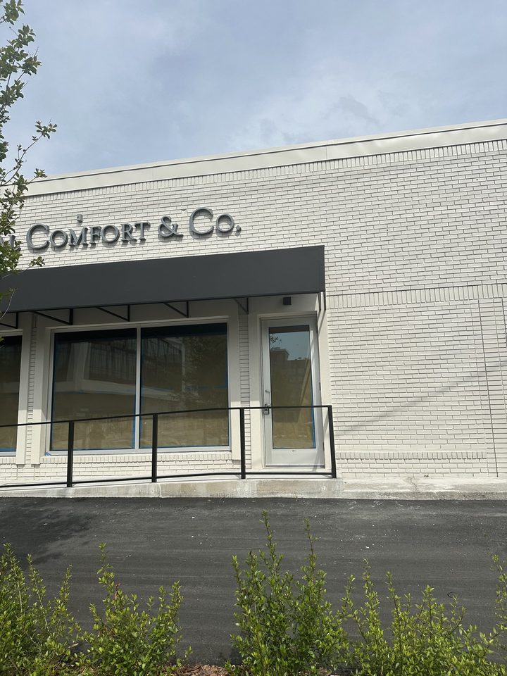 Wide black awning above a white brick storefront