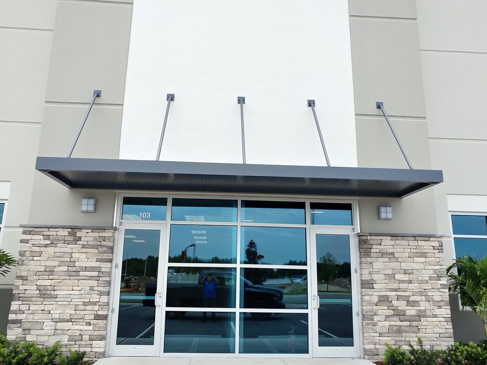 Suspended flat-panel canopy above glass entrance doors