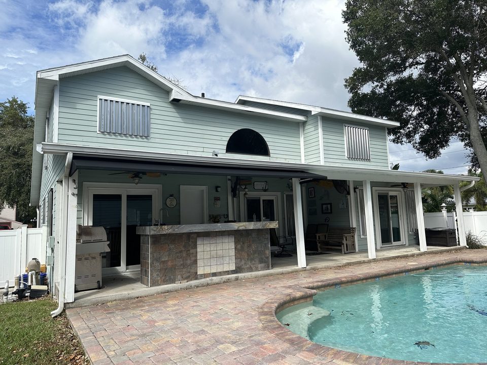 White flat-panel patio cover beside a swimming pool