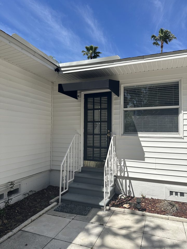 Black awnings above a residential door and window