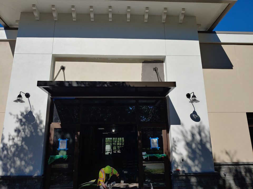 Suspended black canopy above a commercial entrance